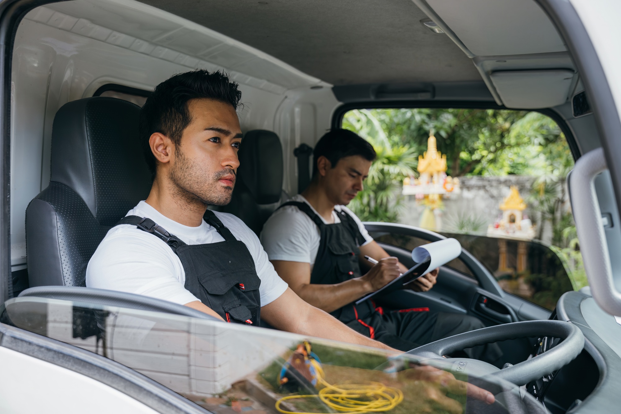 Transporting furniture, Mover workers driving truck for relocation service. Ethnicity diversity in