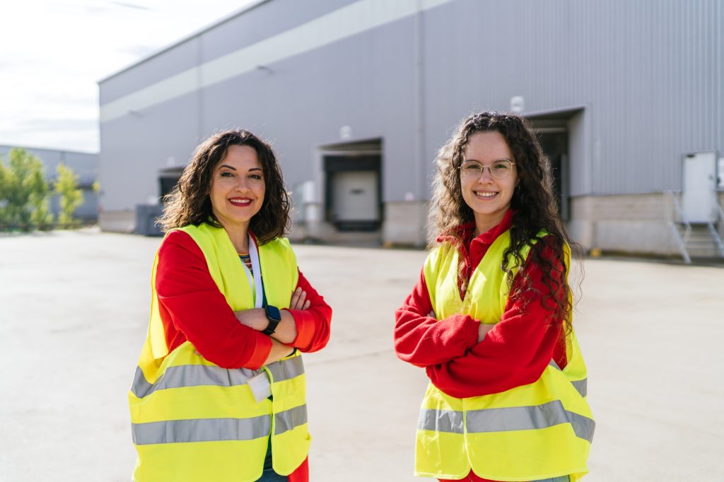 Warehouse workers smiling with arms crossed in logistics center